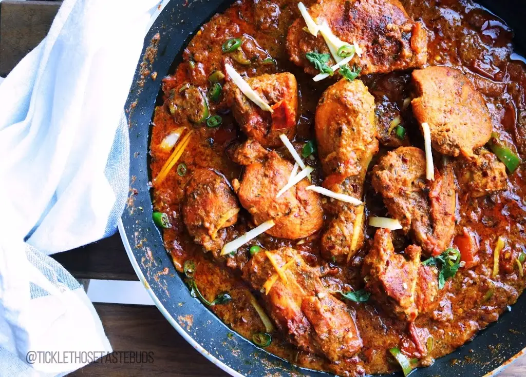 chicken karahi in a wok-style pan with ginger and green chilies